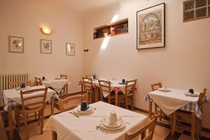 um restaurante com mesas e cadeiras com toalhas de mesa brancas em B&B Arco Antico em Florença