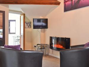 a living room with a fireplace and a tv at The Stable Loft in Bowness-on-Windermere