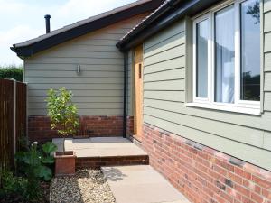 a house with a window and a brick wall at The Boat House in Roughton