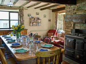 a wooden table with chairs and a dining room at Trowley Farmhouse in Llanbedr