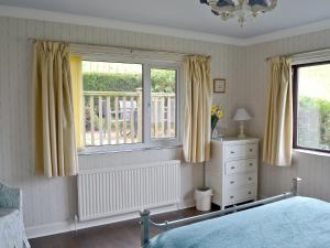 a bedroom with a bed and two windows and a dresser at Cobden View in Sabden