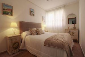 a bedroom with a bed and a table with a lamp at La Luz de La Concha in Suances