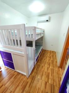 a white bunk bed in a room with a wooden floor at Apartment in Holidays Beach Resort in Bolinao