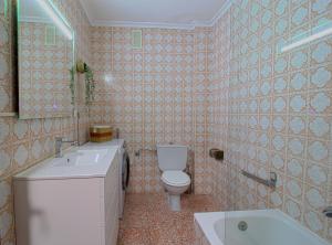 a bathroom with a toilet and a sink and a tub at La Luz de La Concha in Suances +7 photos
