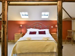 a bedroom with a large bed with orange walls at The Granary-e3567 in Uggeshall