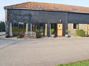 a building with a bench in front of it at The Granary-e3567 in Uggeshall