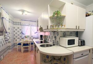 a kitchen with a sink and a microwave at La Luz de La Concha in Suances