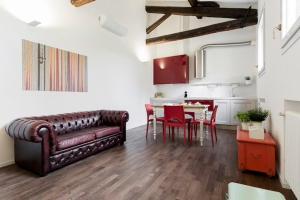 een woonkamer met een bank en een tafel met stoelen bij RED Appartamento immerso tra le mura bolognesi in Bologna
