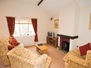 a living room with two couches and a fireplace at Mallard Cottage - E3751 in Leverton