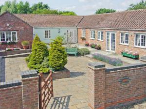 una casa con un patio con árboles y una valla en Mallard Cottage - E3751, en Leverton