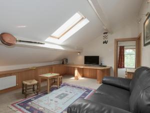 a living room with a couch and a tv at Hazel Grove House in Beetham