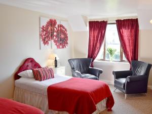 Saint CleerにあるRosecraddoc Manor - Riverviewのベッドルーム1室(椅子2脚、赤い毛布付きのベッド1台付)