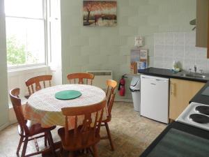 a kitchen with a table and chairs in a kitchen at Upper Tower - 15458 in Cladich