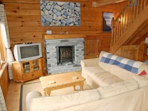 a living room with a couch and a fireplace at Camelog in Little Petherick