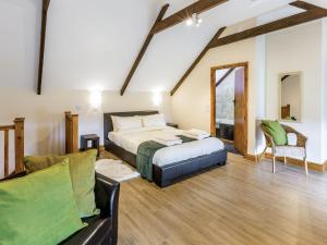 a bedroom with a bed and a couch in a room at Hall Farm Cottage in Byers Green