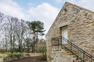 un edificio de piedra con una escalera junto a una ventana en Hall Farm Cottage en Byers Green
