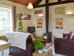 a living room with a couch and a wood stove at Mill Cottage in Stillington