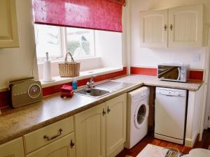 a small kitchen with a sink and a microwave at The School House - 28445 in Middleton in Teesdale