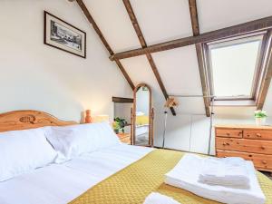 a bedroom with a large bed and a dresser at Dunster Castle Loft - Uk13180 in Dunster