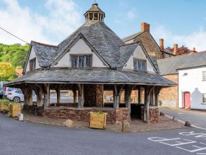 an old building with a roof on a street at Dunster Castle Loft - Uk13180 in Dunster