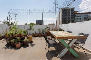 a wooden table and chairs on a patio with plants at Unique 2bedroom PH in Mexico City