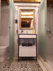 uma casa de banho com um lavatório, um espelho e um WC. em Refuge in Madrid em Madri