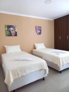 dos camas sentadas una al lado de la otra en una habitación en Hermosa casa amoblada, en Barranquilla