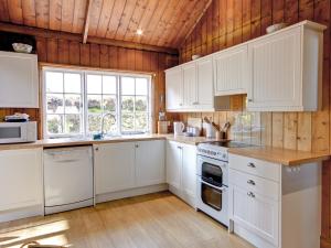 Bargrennan的住宿－佳麗斯木屋別墅，一间厨房,配有白色的橱柜和大窗户