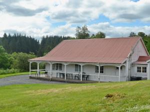 a white house with a red roof on a field at Garlies Lodge in Bargrennan