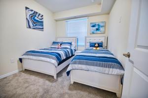 2 Betten in einem Schlafzimmer mit blau und weiß in der Unterkunft Vacation Meadows - Storey Lake by Shine Villas 710 apts in Kissimmee