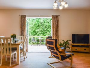 a living room with a dining table and a television at Nuthatch in Buckland Brewer