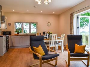 a kitchen and dining room with a table and chairs at Nuthatch in Buckland Brewer