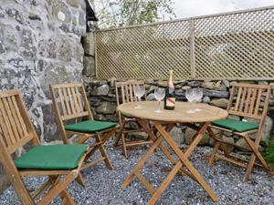クリクキエスにあるGell Cottageの木製テーブル(椅子3脚付)とワイン1本