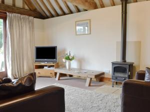 uma sala de estar com lareira e fogão a lenha em The Carthouse em Malmesbury