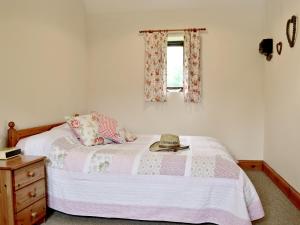 a bedroom with a bed with a hat on it at The Carthouse in Malmesbury