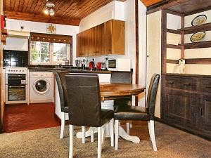 a kitchen with a wooden table and chairs at Summer House in St Asaph