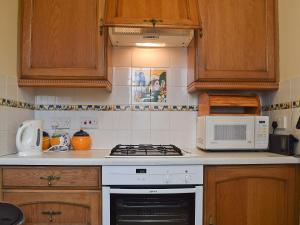 a kitchen with a stove and a microwave at Riverside in Alcester