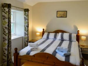 a bedroom with a bed with two towels on it at Wickwoods in Wath