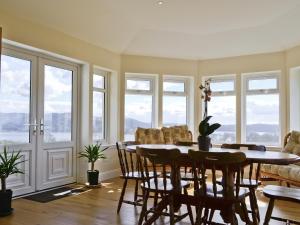 a dining room with a table and chairs and windows at Degnish Farmhouse - Swwu in Kilmelfort