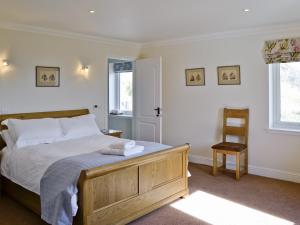 a bedroom with a bed and a chair and a window at Degnish Farmhouse - Swwu in Kilmelfort