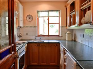 een keuken met een wastafel en een raam bij Woods Cottage in Evershot