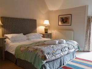 a bedroom with a large bed with white sheets at Mill House in Rievaulx