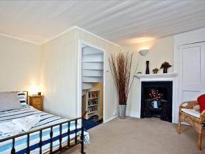 a bedroom with a bed and a fireplace at Pilgrims Cottage in Brixham