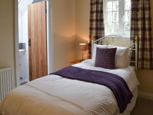 1 dormitorio con 1 cama grande y ventana en Holly Cottage, en Long Houghton