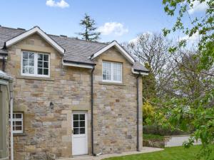 una casa de ladrillo con una puerta blanca en Holly Cottage, en Long Houghton