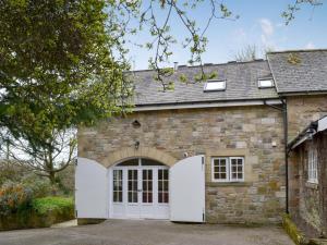 a stone house with white doors and a garage at Holly Cottage in Long Houghton