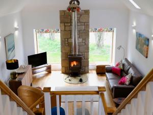 a living room with a fireplace and a couch at The Barn in Ankerville