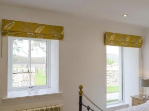 two windows with yellow roman blinds in a bedroom at The Barn in Ankerville