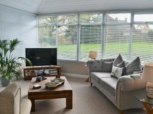 a living room with a couch and a table at Elm Tree Cottage in Foxholes