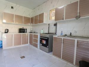 a kitchen with wooden cabinets and a stove top oven at Red_Hut_Resort in Sharīyah